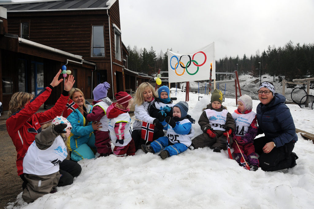 OLYMPISK SAMLING: Et knippe små og store OL-deltakere samlet foran OL-ilden og OL-flagget.