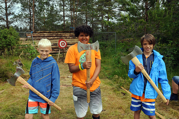 ØKSEKASTERE: Birkenes Jerv-guttene Kristian (f.v.), George og Marcus etter vel gjennomført øvelse i øksekasting, som var en del av Farmen-aktivitetene. 