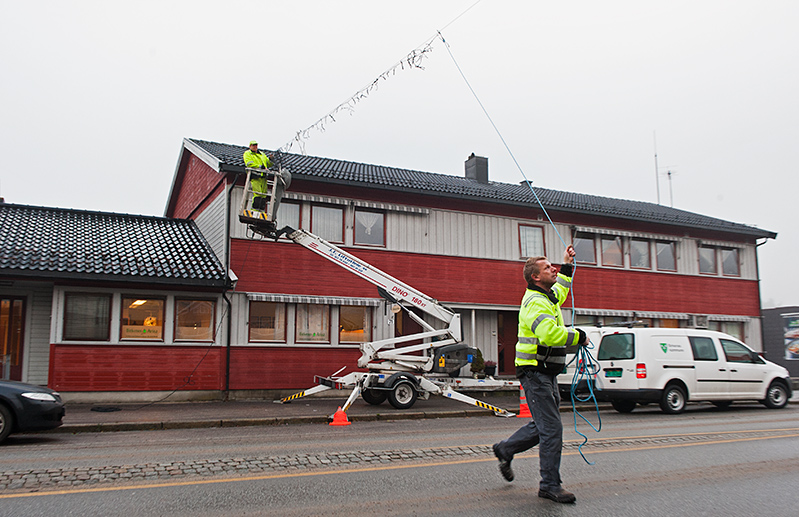 JUL: Tor Einar Holm arbeider i høyden, mens Finn Landås drar lyslenka over Strøget på Birkeland.