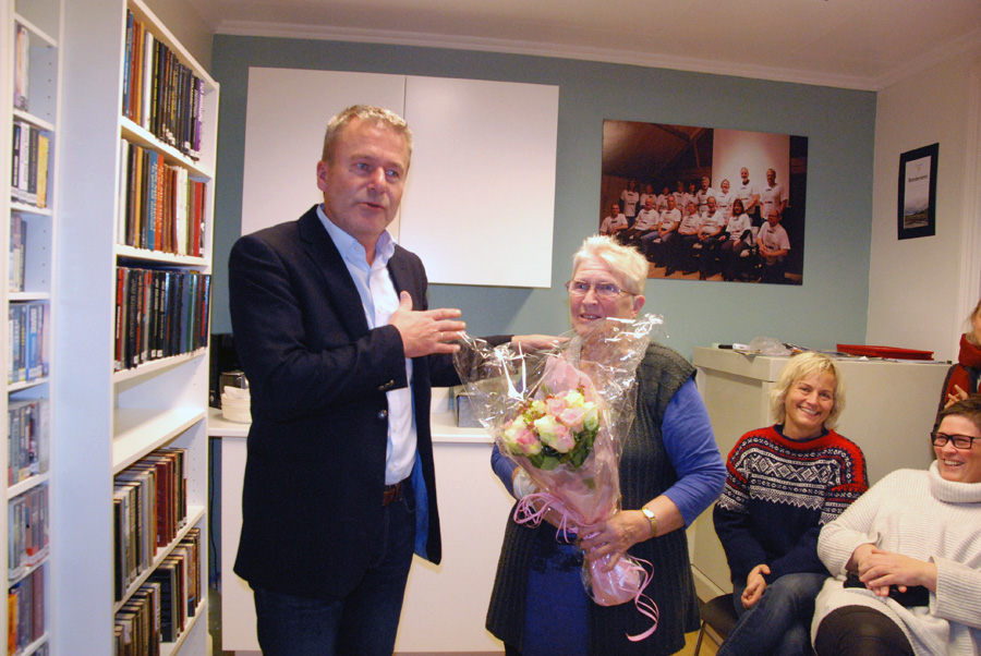 OVERREKKELSE: Sjefen i Birkens Sparebank Harald Flaa overekker Signe Fidje blomster for hennes engasjement i bokkafeen.